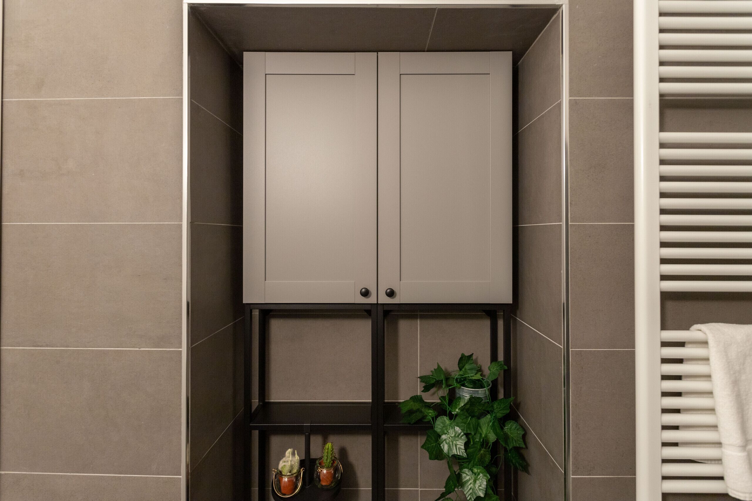 Ein Badezimmer mit Schrank, Ablagen und Handtuchhalter.