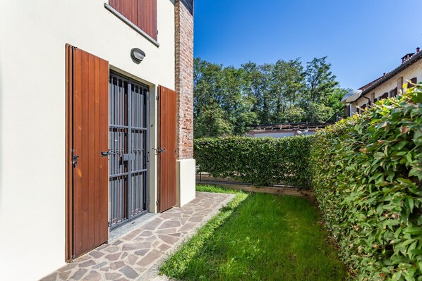 A building with a stone pathway leading to a wooden door with metal bars.