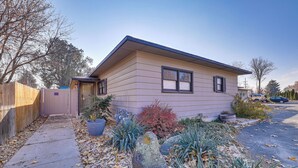 A single-story house with a sloped roof, a front porch, and a driveway leading to a parked car. - Charming Nampa Retreat w/ Patio: 20 Mi to Boise! (Nampa)