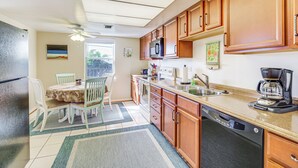A kitchen with wooden cabinets, a microwave, a coffee maker, and a dishwasher. - Sebastian Home w/ Large Deck Near Golfing & Beach (Sebastian)