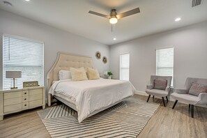 A bedroom with a bed, nightstand, chair, and ceiling fan. - 3 Mi to Usf: Dog-friendly Home w/ Large Yard (Lutz)