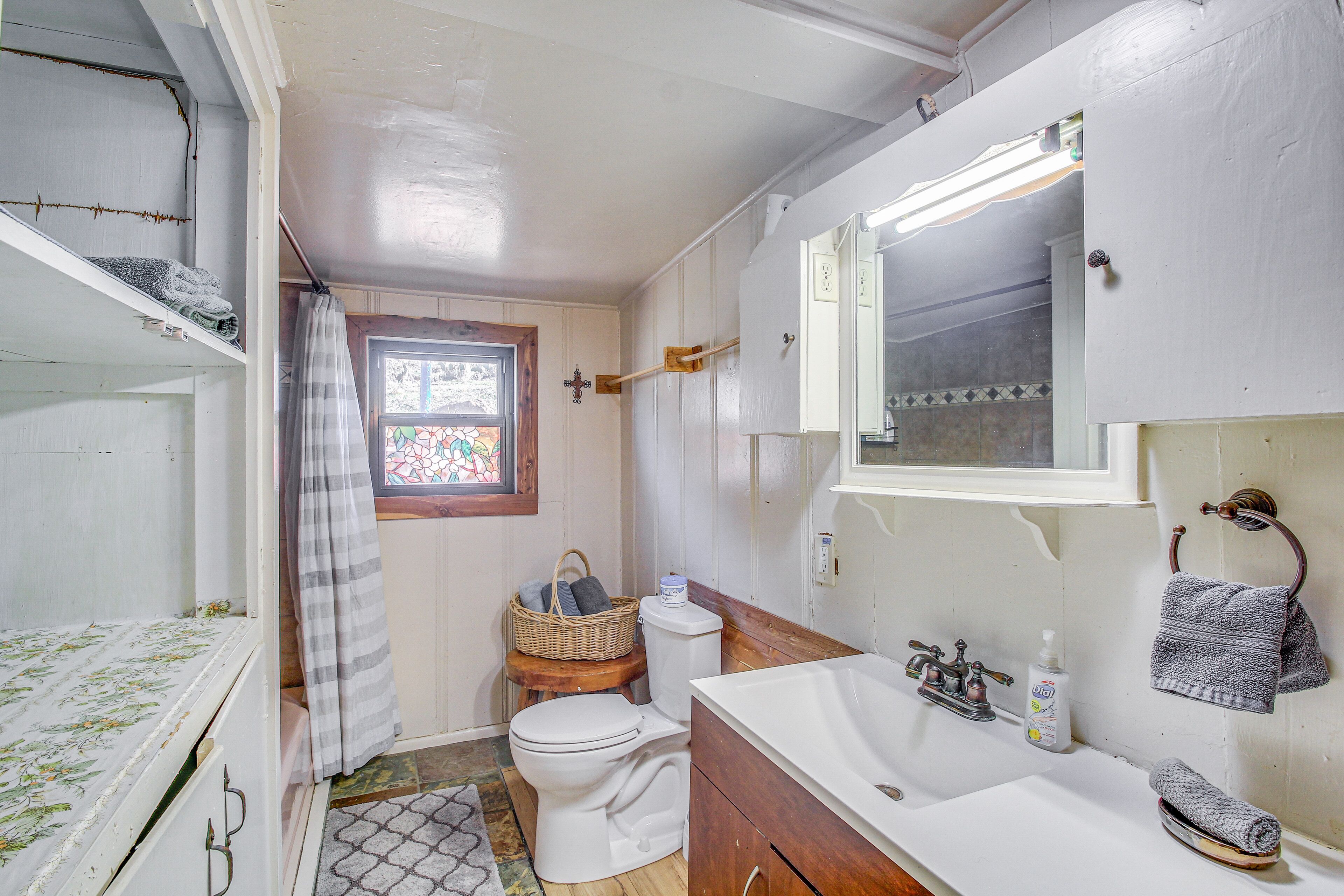 A small, compact bathroom with a toilet, sink, and shower area.