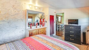 A bedroom with a bed, dresser, mirror, and a television. - Medicine Park Getaway: Kayaks, Deck & Mtn Views! (Medicine Park)