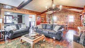 A spacious living room with a large sofa set, a coffee table, and a dining area with a table and chairs. - Medicine Park Getaway: Kayaks, Deck & Mtn Views! (Medicine Park)