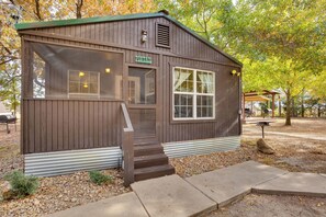 A small wooden cabin with a porch, a window, and a door. - Grill & Dock Access: Waterfront Kerens Cabin (Kerens)