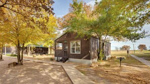 Une petite cabane en bois avec un porche, une boîte aux lettres et un chemin piétonnier dallé.
