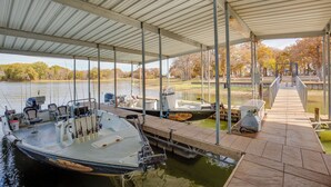 Un quai abrité avec plusieurs bateaux amarrés, une chaise placée sur le quai et un système de filtration de l’eau.