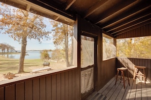A wooden deck with a view of a lake and trees.