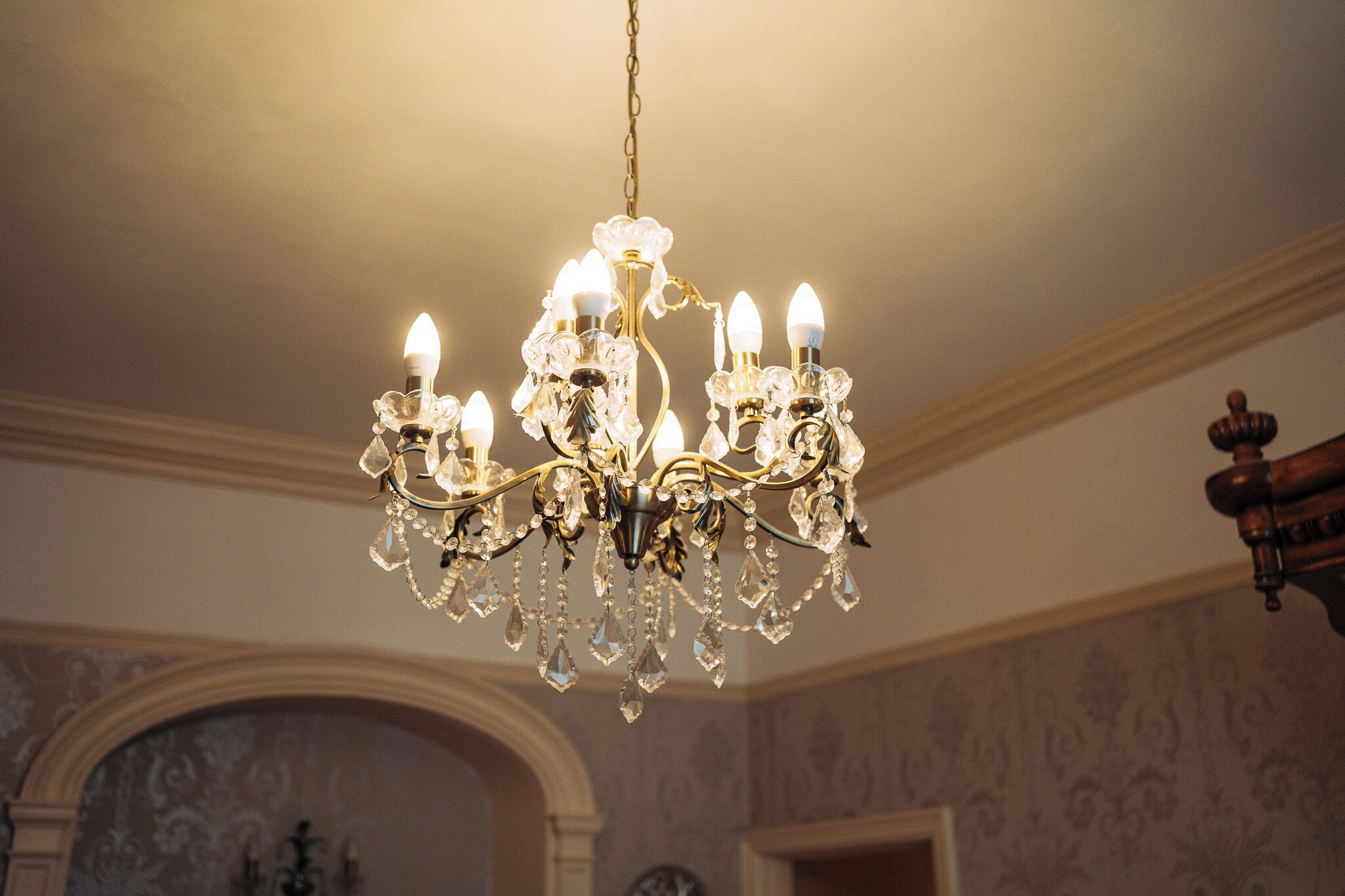 Een kroonluchter met meerdere lampen en kristaldecoraties.