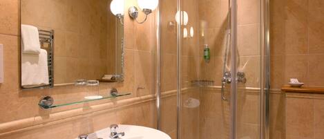 A modern bathroom with a glass-enclosed shower, a white sink with two faucets, and a large mirror.