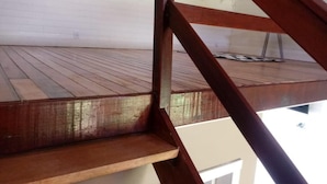 A wooden staircase leading to a wooden deck with a white ceiling. - Pousada Toscana Cambará (Cambara do Sul)