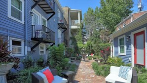 A courtyard with outdoor seating, a stone pathway, and a water feature.
