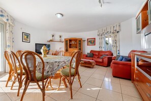 Un área de comedor con una mesa, sillas, un sofá y un armario.