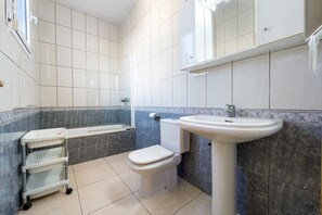 A bathroom with a toilet, sink, and bathtub.