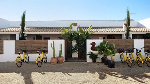 A building with a tiled roof, a wooden fence, and a gravel driveway.