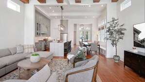 A spacious living area with a sofa set, a coffee table, and a dining area with chairs and a table.