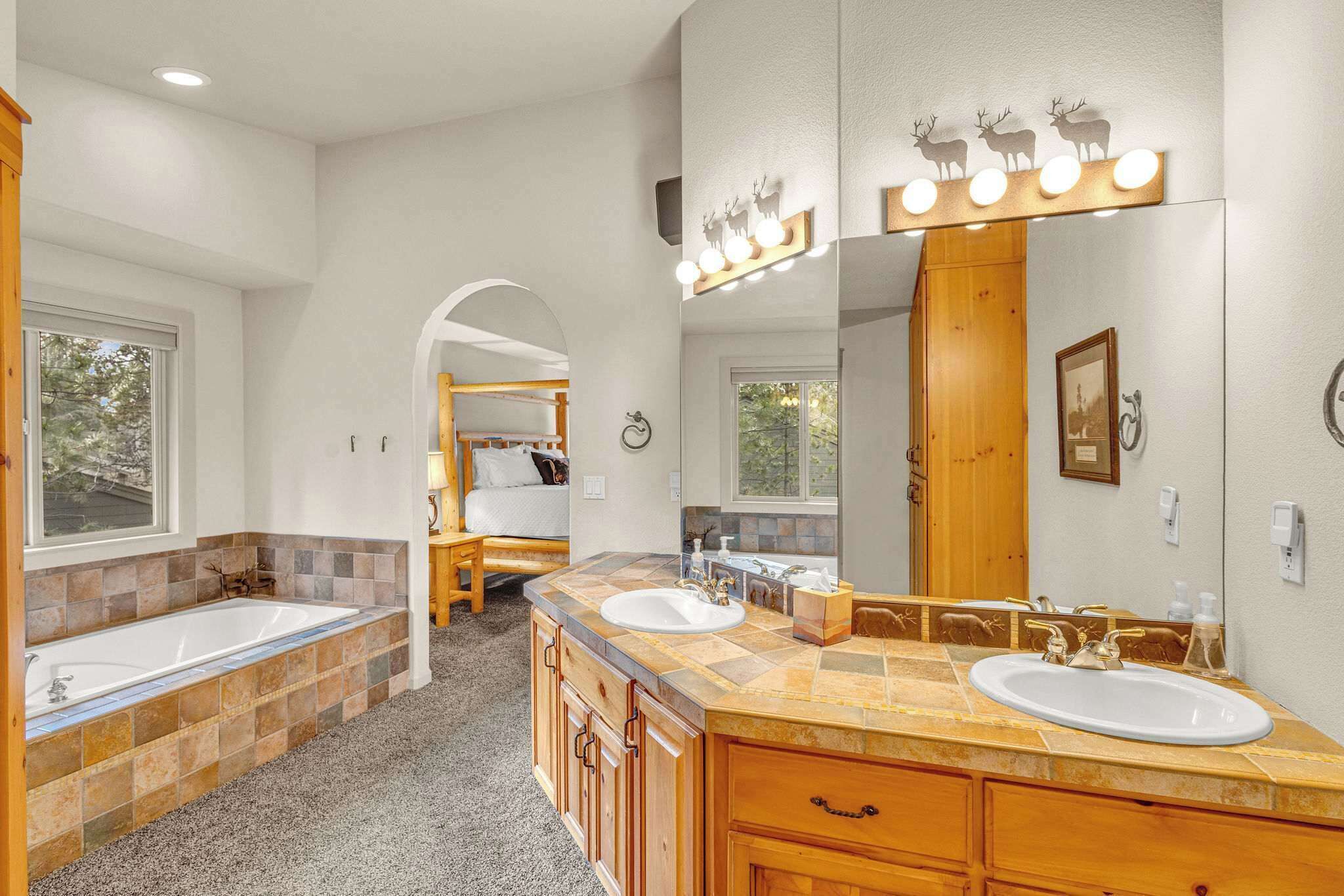 A bathroom with two sinks, a large mirror, and a vanity with drawers.