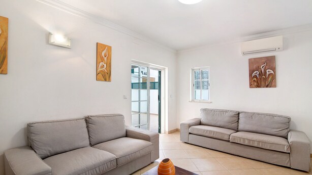 A living room with two sofas, a vase on a table, and artwork on the walls. - Holiday Home 'Moradia Altura' with Private Terrace and Balcony (Altura)