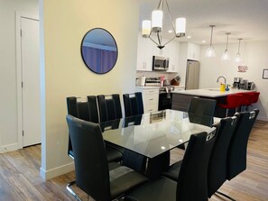 A modern kitchen with white cabinets, a microwave, and a refrigerator.