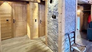 Een houten interieur met een stenen muur, houten deuren en een stoel.