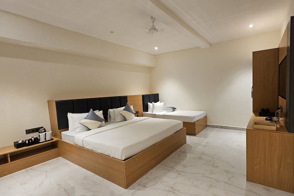 Un dormitorio moderno con una cama grande, una cama más pequeña, un tocador y un espejo.