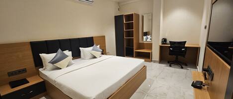 Une chambre d’hôtel moderne avec un grand lit, un bureau et une armoire.