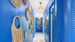 A hallway with blue walls, decorative woven items, and a ceiling light. - Santorini · Casa Santorini - Big Pool, BBQ & Free Parking (Miami)