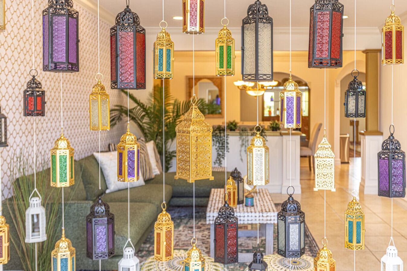 A hotel lobby with hanging lanterns, a sofa, and a coffee table.