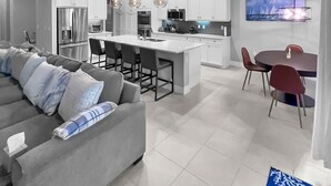 A modern kitchen with white cabinets, a central island, and pendant lighting.