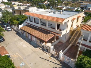 A two-story building with a flat roof, a balcony on the upper floor, and a covered patio area. - 3651 Casa Iro by Barbarhouse (Porto Cesareo)