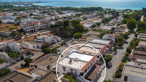 Vue aérienne d’une ville côtière, avec un mélange de bâtiments résidentiels et d’espaces ouverts.