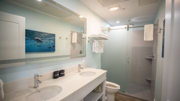 Un baño moderno con dos lavamanos, un espejo grande y una zona de ducha.