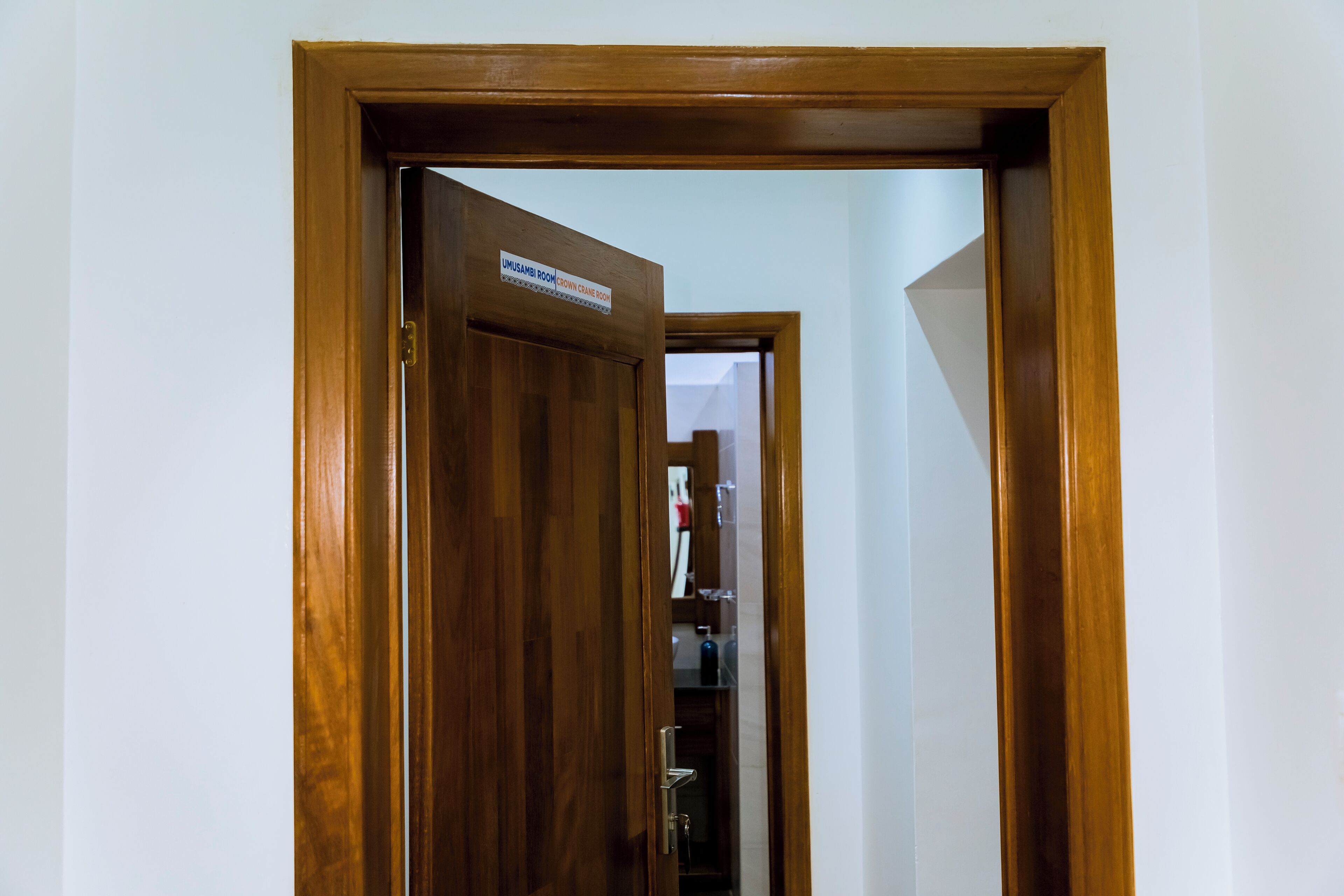 Una puerta de madera con un cartel que dice "UMUSAMBI ROOM CROWN CRANE ROOM".