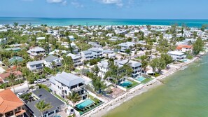 A coastal residential area with houses, a beach, and a pool.