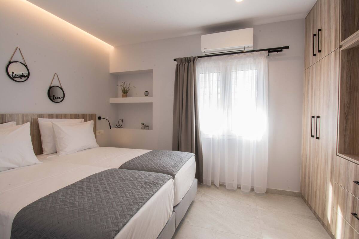 Ein modernes Schlafzimmer mit einem großen Bett, einem Kleiderschrank und einem kleinen Regal mit Dekoration.