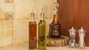Four bottles of varying shapes and sizes on a countertop. - Gianna's House Next To Platanias, 250m From Beach (Platanias)