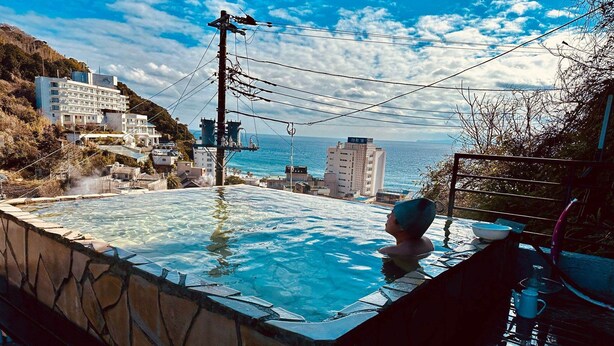Un jacuzzi con vistas a la costa y edificios al fondo.