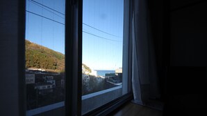 Una habitación con amplias ventanas que dan a un paisaje urbano y una colina.