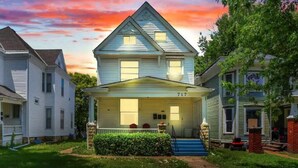 A two-story house with a front porch, a number '717' on the front, and a well-maintained lawn. - Kg Bd Full Condo steps to hospitals & Capitol 1-70 (Topeka)