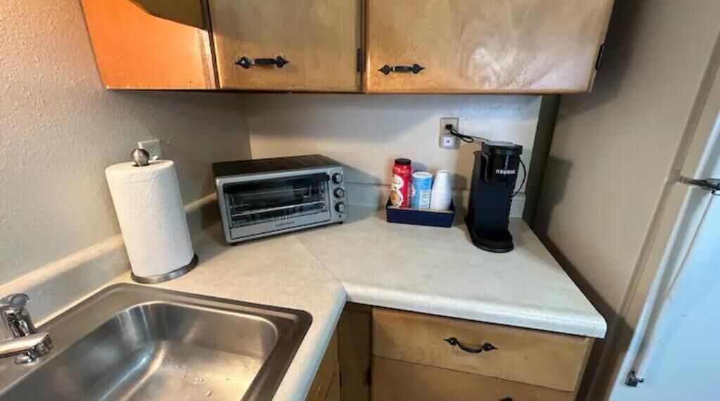 Une petite cuisine équipée d’un grille-pain, d’une machine à café et d’un évier.