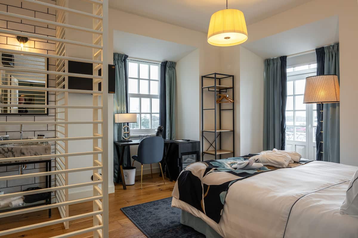 Ein modernes Hotelzimmer mit Bett, Schreibtisch und Kleiderschrank.