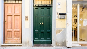 Three doors: a wooden door, a green door, and a glass door with a sign. - Terrace on the roof by Mmega (Florence)