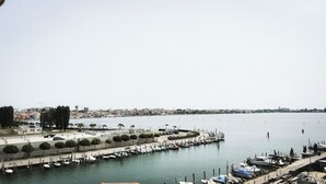 Ein Hafen mit vertäuten Booten, eine Uferpromenade und eine entfernte Skyline.