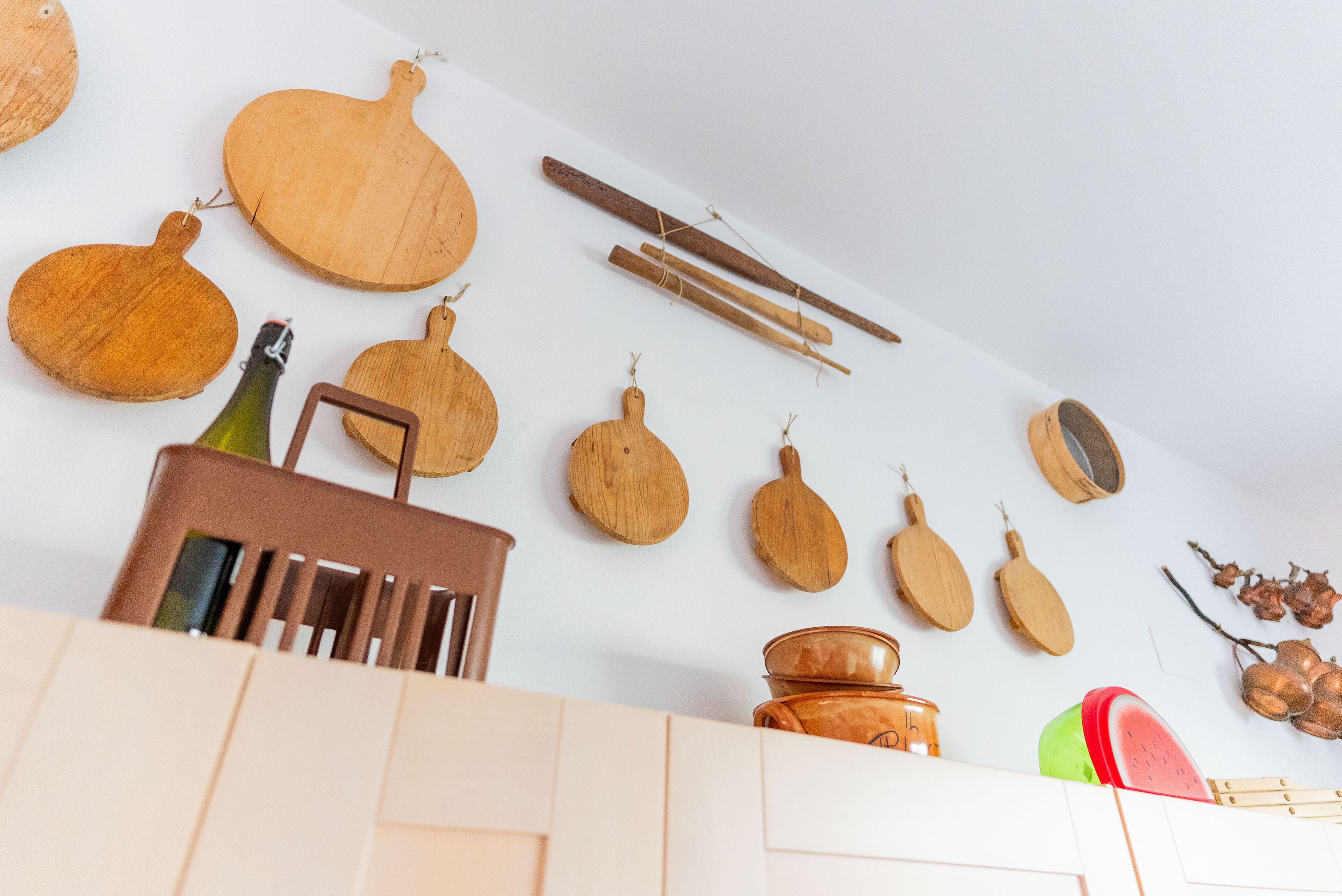Une cuisine avec des planches à découper en bois, une bouteille et une casserole sur le comptoir.
