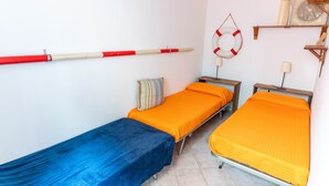 A room with two single beds, a blue bedspread, and an orange bedspread. - Casa Aprilia by Ca-Sa Check (Venezia)
