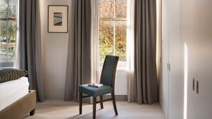 A bedroom with a bed, a chair, a window with curtains, and a framed picture on the wall. - Sublime 4BD House W/park Views - London Fields! (London)