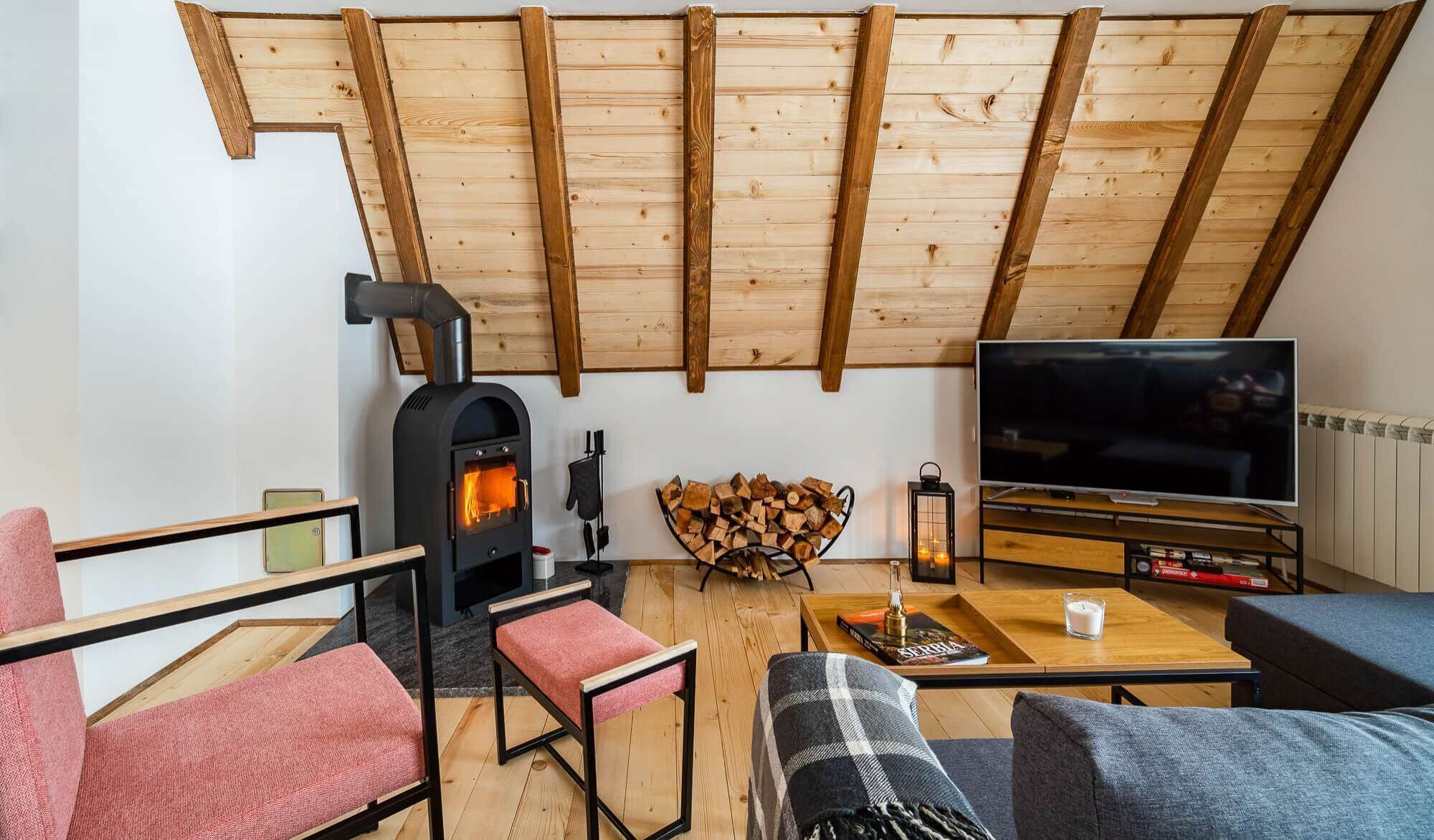 Una sala de estar acogedora con chimenea de leña, televisión y asientos cómodos.