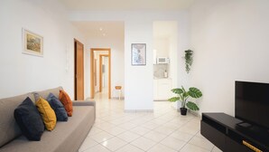 A living room with a sofa, TV, and potted plants. - IV HOUSE
Luxurious apartment in Rome (Roma)
