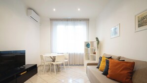 A modern living room with a flat-screen TV, a dining table with chairs, a sofa with cushions, and a bookshelf. - IV HOUSE
Luxurious apartment in Rome (Roma)
