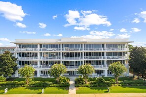 A multi-story hotel with a central courtyard, balconies, and lush landscaping.